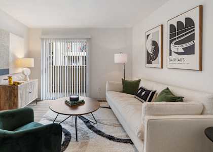 a living room with a white couch and green chairs