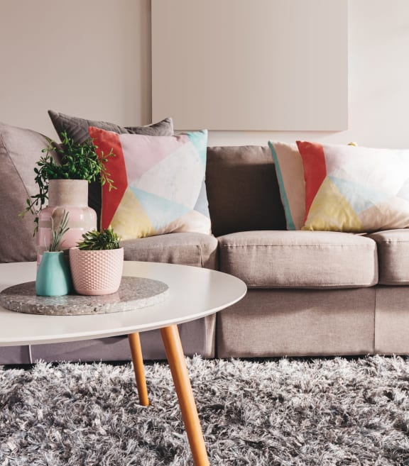 A living with a sofa and coffee table with potted plants at Zinfandel Village Apartments, Rancho Cordova, California 95670