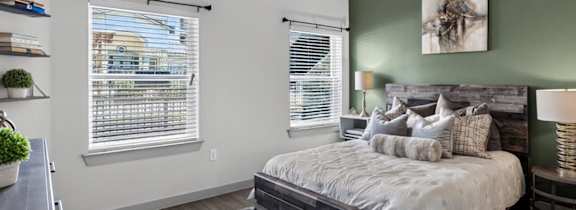 A bedroom with a bed, a ceiling fan, and a window with blinds.