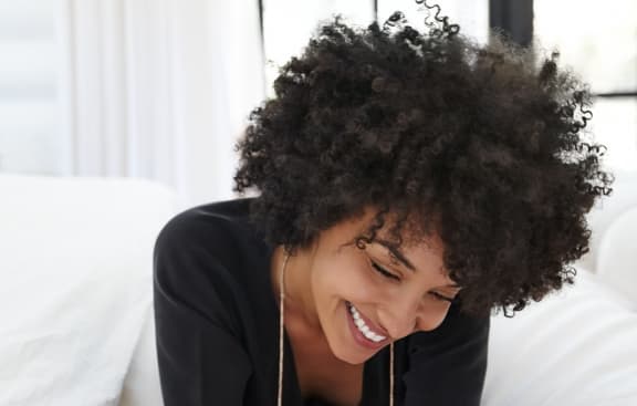 curly hair woman smiling looking down