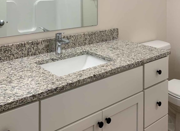a bathroom with a large vanity, sink, and a mirror