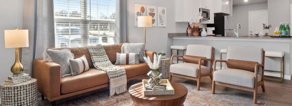 a living room with couches and chairs and a ceiling fan