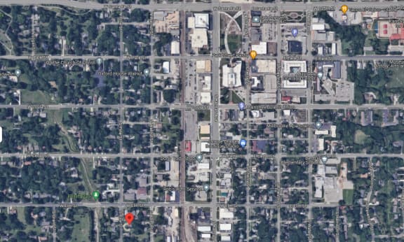 a satellite map of a city with a red circle and a yellow dot