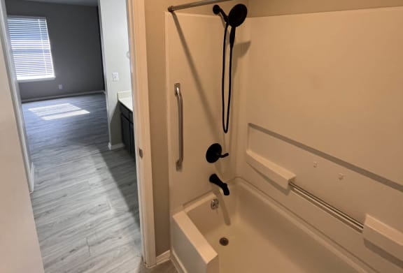 a bathroom with a bathtub and a shower at The Lodge Apartments, Tulsa, OK