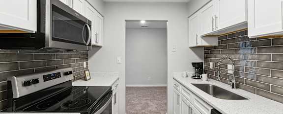 A kitchen with white cabinets and stainless steel appliances.