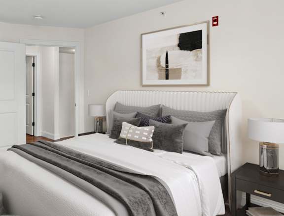 A bedroom with a bed, nightstand, and a painting on the wall.