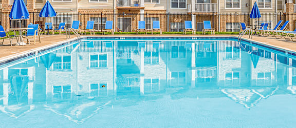 A large swimming pool in front of apartment buildings.