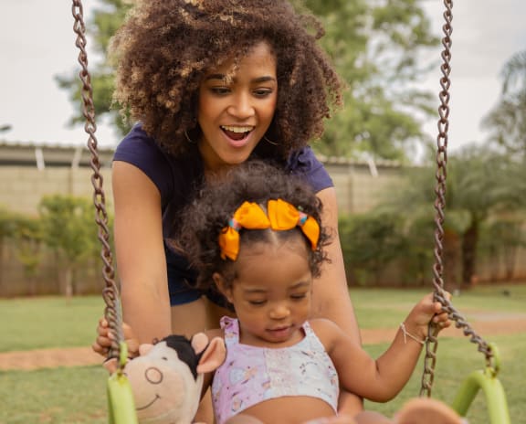 a mother and daughter sitting on a swing