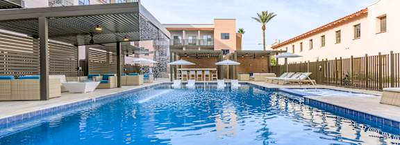 A large indoor swimming pool with a sunny day outside.