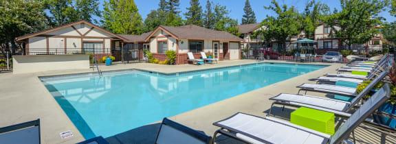 Rocklin Manor pool area with updated pool deck, with lounge chairs, and pots with flowers. 