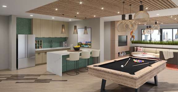 A billiard table is in the middle of a room with a kitchen area.