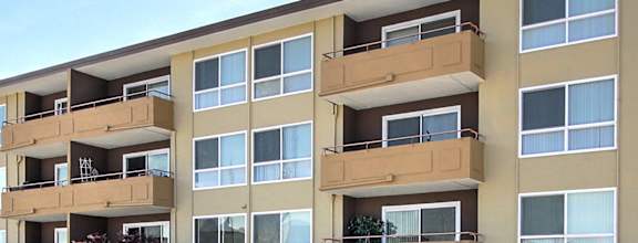 A Madison Place apartment building with a parking lot in front.