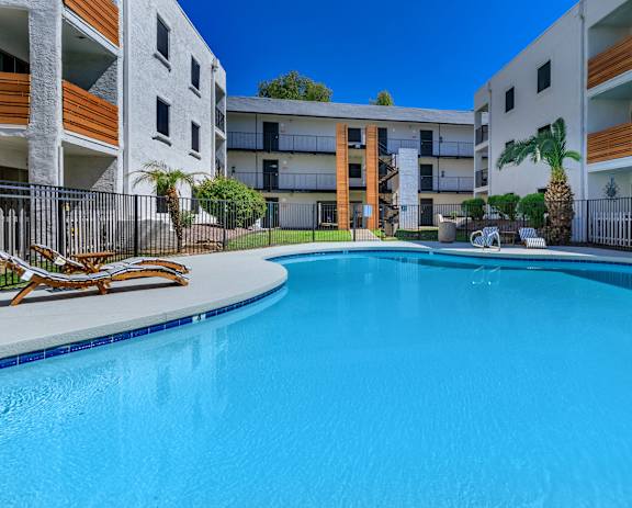 a large swimming pool in front of an apartment building