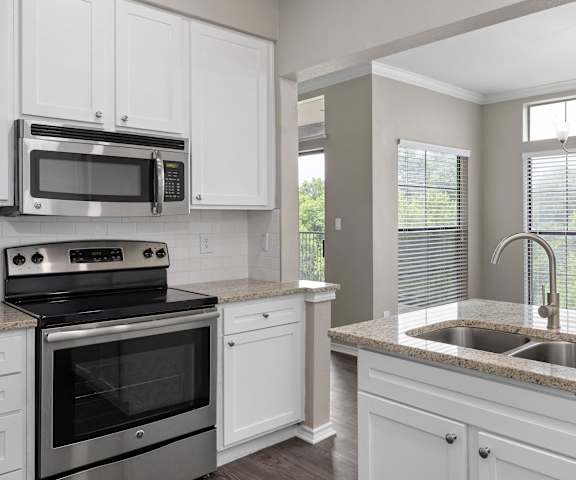 an empty kitchen with white cabinets and a sink at Waters Edge Apartment Homes, Georgetown