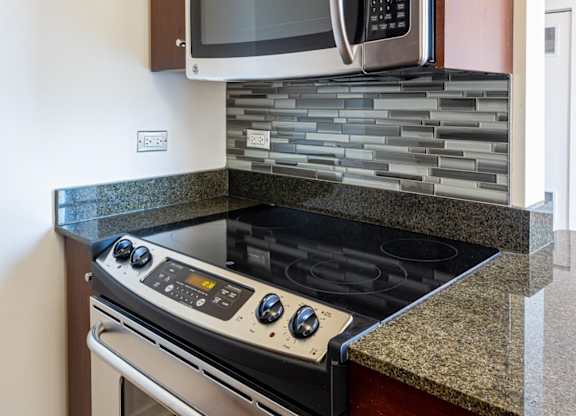 A modern kitchen with a stove top oven and microwave above it.