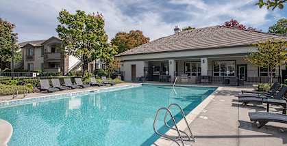 Stoneridge apartments pool, lounge chairs, BBQ grill, and clubhouse 