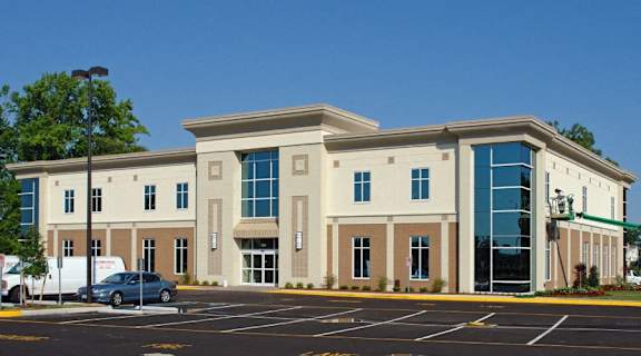 an office building with a car parked in a parking lot