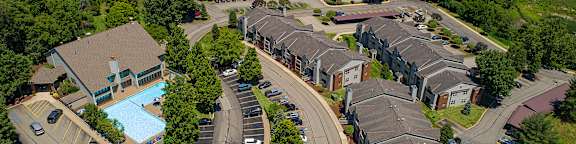 A bird's eye view of a residential area with houses, roads, and a swimming pool.