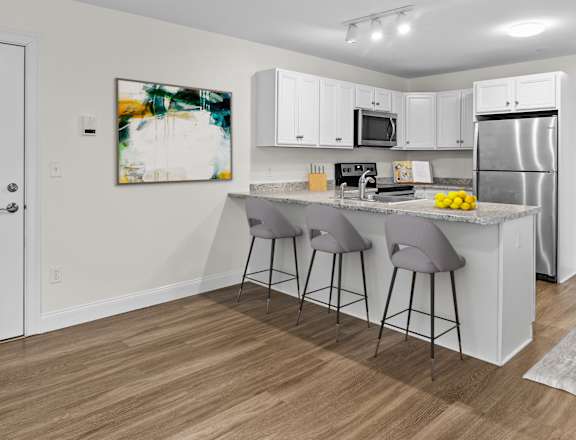 a kitchen with white cabinets and a island with two stools