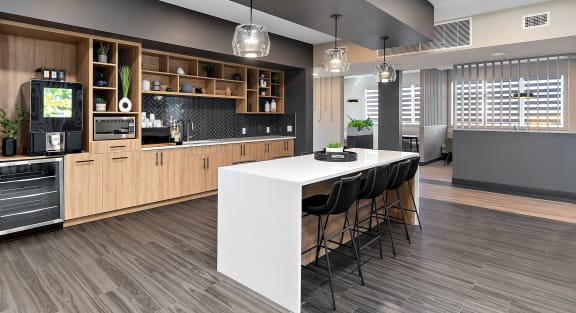 a large kitchen with a white island and black chairs