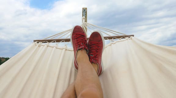 man in hammock with red shoes