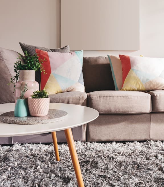 a living room with a sofa and coffee table with potted plants at Sunset Summit in Rocklin, CA 95765