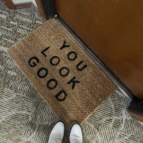 A doormat with the words "you look good" written on it.