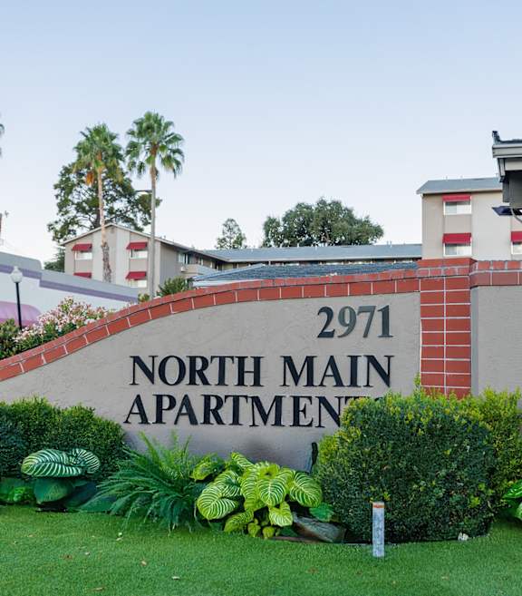 A sign for North Main Apartment 2971 is displayed in front of a building.