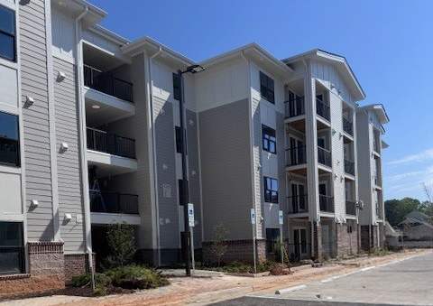 A parking lot in front of a multi-story apartment building.