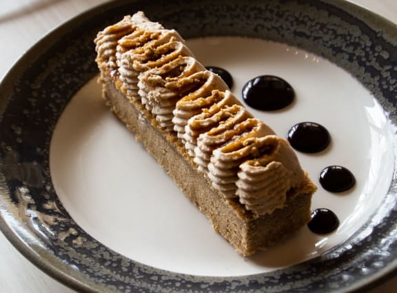 a slice of cake on a plate with chocolate cherries and whipped cream