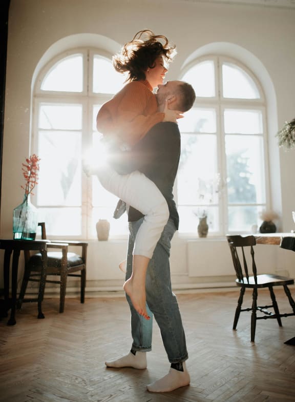 a man holding a woman in a living room