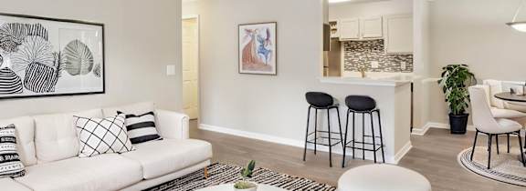 A living room with a white couch, a coffee table, and a ceiling fan.