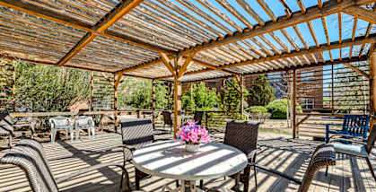 a patio with a table and chairs under a roof