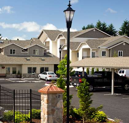 A street view of a residential area with houses and parked cars.