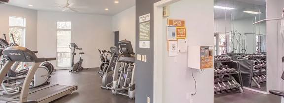 A gym with treadmills, exercise bikes, and other equipment.
