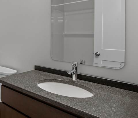 an empty bathroom with a toilet sink and mirror