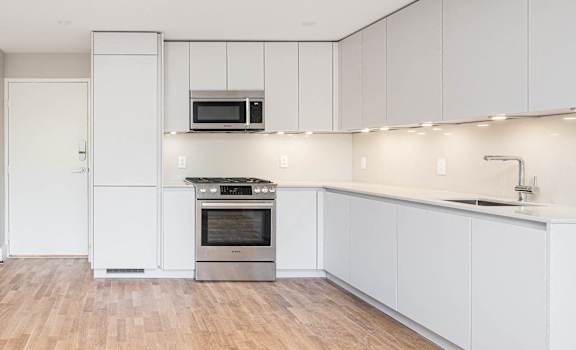 Open concept dining and living rooms with hardwood floors and ample natural light