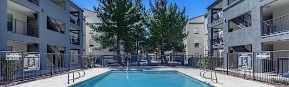 A swimming pool in a residential area surrounded by apartment buildings.