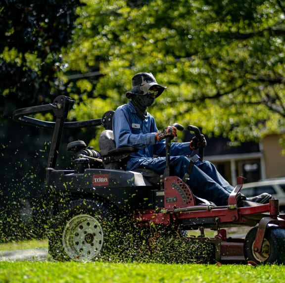 a man riding on a tractor in the grass