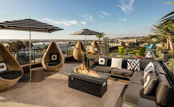 A patio with a fire pit and seating area.