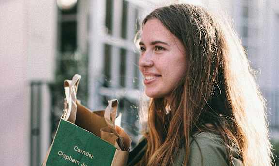 a woman holding a paper bag of food