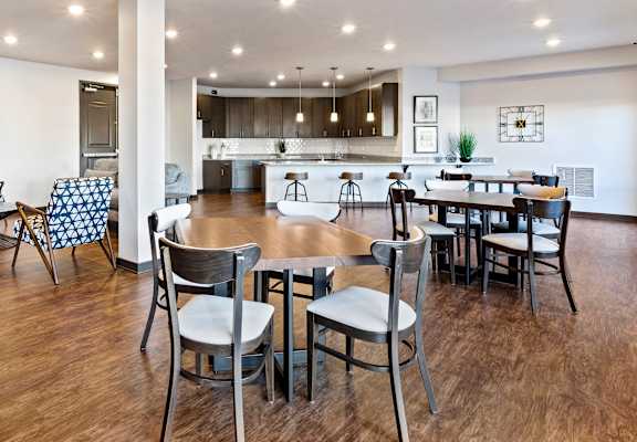 Showcasing the vast community room at Ashburn Chase.  Ample tables and seating for community events or gatherings.  Fully appointed kitchen for community cooking.