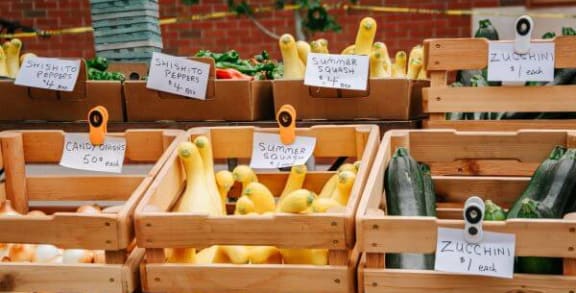 a bunch of crates filled with different types of vegetables