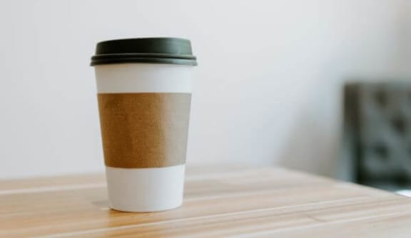 a cup of coffee sitting on top of a wooden table