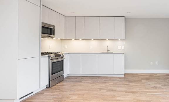 Open concept dining and living rooms with hardwood floors and ample natural light
