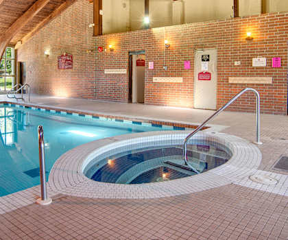 The indoor pool with tables and chairs at Edgemont Heights. 