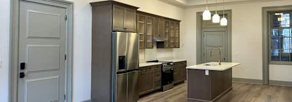 a kitchen with stainless steel appliances and wooden cabinets  | Bishops Court Apartments