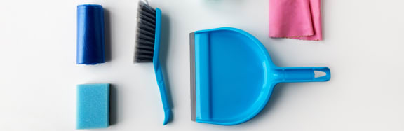 a collection of blue and pink cleaning supplies laid out on a white surface