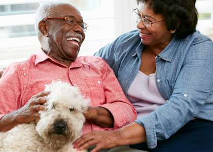 Lifestyle photo of couple at home with their dog at RAINIER VISTA SENIOR APARTMENTS, PACIFIC, Washington