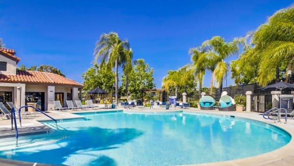a large swimming pool with palm trees around it  at Vista Promenade Apartments, California
